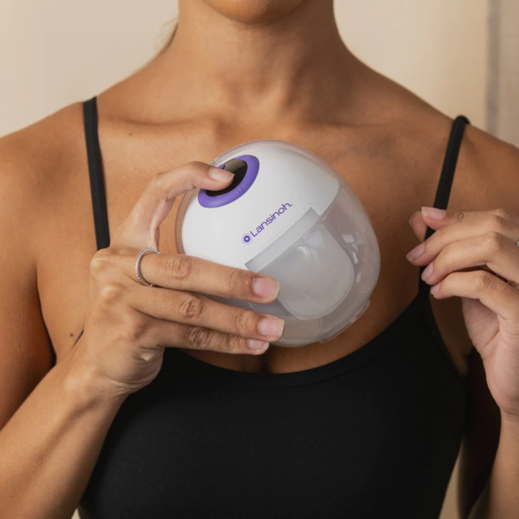 a woman holding low-profile Lansinoh breastmilk pump, about to attach to her breast
